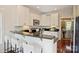 Modern kitchenette featuring black counters, white cabinets, stainless appliances, and breakfast bar seating at 1824 Hall Ave, Charlotte, NC 28205