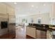 Kitchenette features stainless steel refrigerator, black countertops, white cabinets, and seamless access to living room at 1824 Hall Ave, Charlotte, NC 28205