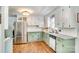 Charming kitchen featuring light green and white cabinets, granite countertops, and stainless steel appliances at 1938 Hickory Dr, Lancaster, SC 29720