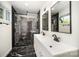 Modern bathroom featuring double sinks, glass shower doors, and stylish black and white tile at 2014 Sandhurst Dr, Charlotte, NC 28205