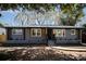 Charming gray brick home featuring a welcoming front porch and well-maintained landscaping at 2014 Sandhurst Dr, Charlotte, NC 28205