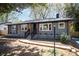 Charming gray brick home featuring a welcoming front porch and well-maintained landscaping at 2014 Sandhurst Dr, Charlotte, NC 28205