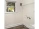 Utility room with window, shelving, water hookups and gray plank flooring at 2014 Sandhurst Dr, Charlotte, NC 28205