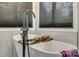 Elegant bathroom with a modern standalone tub complemented by a sleek faucet and natural light at 2058 Manila Bay Ln, Fort Mill, SC 29708