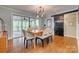 Elegant dining room with hardwood floors, a stylish light fixture, and sliding glass doors to a screened porch at 2058 Manila Bay Ln, Fort Mill, SC 29708