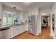Modern kitchen with stainless steel refrigerator, granite countertops, gray backsplash and white cabinets at 2058 Manila Bay Ln, Fort Mill, SC 29708