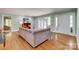 Stylish living room showcasing hardwood floors, a spacious sectional sofa, and large windows for natural light at 2058 Manila Bay Ln, Fort Mill, SC 29708