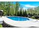 Backyard featuring a pool, green trees, and a sitting area at 2315 Collins Dr, Albemarle, NC 28001