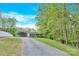 Inviting home with charming front porch, gravel driveway, and spacious carport nestled among lush trees at 2315 Collins Dr, Albemarle, NC 28001