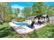 Inviting backyard pool area featuring a covered patio, lounge chair and a lush, green lawn at 2315 Collins Dr, Albemarle, NC 28001