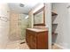 Updated bathroom with tiled shower, granite vanity, and open shelving for storage at 2615 Toddville Rd, Charlotte, NC 28214