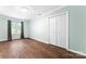 Bedroom featuring wood-look flooring, a window with curtains, and a double-door closet at 2615 Toddville Rd, Charlotte, NC 28214
