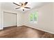 Bedroom with wood-look flooring, ceiling fan, and window offering bright natural light at 2615 Toddville Rd, Charlotte, NC 28214