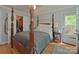 Well-lit bedroom featuring a four-poster bed, closet, and an exit door, creating a cozy retreat at 3063 Wimbledon Ln, Rock Hill, SC 29732