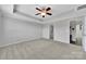 Bright bedroom featuring tray ceilings, neutral carpeting, and ensuite bathroom access at 314 Wave Crest Dr, Tega Cay, SC 29708