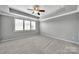 Bedroom with tray ceiling, neutral carpeting, and shuttered windows at 314 Wave Crest Dr, Tega Cay, SC 29708