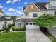 Charming home exterior featuring a stone facade, two-car garage, well-maintained lawn, and lush green landscaping at 314 Wave Crest Dr, Tega Cay, SC 29708