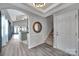 Inviting foyer featuring a staircase, modern flooring, decorative mirror, and an open view to the kitchen at 314 Wave Crest Dr, Tega Cay, SC 29708