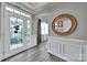 Elegant foyer with decorative glass door, stylish flooring, wainscoting, and a round mirror at 314 Wave Crest Dr, Tega Cay, SC 29708