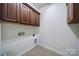 Bright laundry room featuring upper cabinets, tile flooring, and utility connections at 314 Wave Crest Dr, Tega Cay, SC 29708