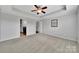 Spacious main bedroom featuring tray ceilings, neutral carpeting, and ensuite bathroom access at 314 Wave Crest Dr, Tega Cay, SC 29708