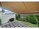 Relaxing covered patio with a patterned rug and white privacy fence surrounded by lush greenery at 314 Wave Crest Dr, Tega Cay, SC 29708