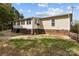 View of the back of the house with tan siding, a brick foundation, and a spacious yard at 335 Ridgewood Dr, Mt Ulla, NC 28125