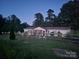 Inviting evening view of the house with charming fence and beautifully landscaped front yard at 335 Ridgewood Dr, Mt Ulla, NC 28125