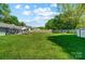 Large backyard with lush green grass, patio area, and tall trees at 3612 Cobbleridge Dr, Charlotte, NC 28215