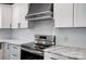 Close-up of a stainless steel stove with a decorative range hood and marble countertops at 3612 Cobbleridge Dr, Charlotte, NC 28215
