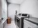 Laundry room featuring modern appliances, a gray cabinet, and marble tile flooring at 3612 Cobbleridge Dr, Charlotte, NC 28215