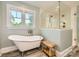 Bright bathroom featuring soaking tub, glass shower, and a view to the outside at 3709 Commonwealth Ave, Charlotte, NC 28205