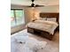 Comfortable main bedroom featuring a rustic wood bed frame, ceiling fan, and a view to the outdoors at 3713 Saint Regis Dr, Gastonia, NC 28056