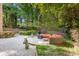 Private backyard with stone patio, built-in seating around a fire pit, and lush landscaping at 3819 Gleneagles Rd, Charlotte, NC 28210