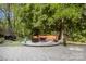 Backyard featuring a patio with outdoor seating area, statues and lush trees at 3819 Gleneagles Rd, Charlotte, NC 28210