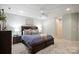Relaxing bedroom with a dark wood bed frame, soft carpet, and ambient lighting at 3819 Gleneagles Rd, Charlotte, NC 28210