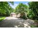 Long driveway leading to a traditional brick home with lush landscaping and a three-car garage at 3819 Gleneagles Rd, Charlotte, NC 28210