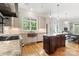 This kitchen showcases a center island, stone countertops, custom cabinets, and a copper sink beneath the window at 3819 Gleneagles Rd, Charlotte, NC 28210