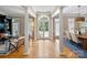 Spacious living room featuring large windows, hardwood floors, and classic columns offering ample natural light at 3819 Gleneagles Rd, Charlotte, NC 28210
