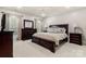 Large main bedroom with neutral tones, plush carpet, and matching dark wood furniture at 3819 Gleneagles Rd, Charlotte, NC 28210
