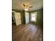 Cozy bedroom with wood-look flooring, a ceiling fan, and natural light at 427 W Whitley St, Norwood, NC 28128