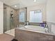Modern bathroom featuring a glass shower, and soaking tub, designed for relaxation and comfort at 4606 Gatesmills Ave, Charlotte, NC 28213