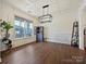 Bright living room with hardwood floors, large windows, and a stylish light fixture at 4606 Gatesmills Ave, Charlotte, NC 28213