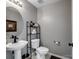 Stylish half bathroom with a pedestal sink, modern fixtures, and decorative shelving at 4665 Madeline Dr, Rock Hill, SC 29732