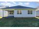 Rear view of a light blue house with a covered patio and green lawn at 5043 Antebellum Dr, Iron Station, NC 28080