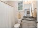 Well-lit bathroom with granite countertop, a gray vanity, a decorative mirror, and a shower with a white curtain at 5043 Antebellum Dr, Iron Station, NC 28080