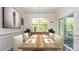 Bright dining room with a modern chandelier, wooden table, and sliding glass doors to the backyard at 5043 Antebellum Dr, Iron Station, NC 28080
