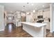 Bright kitchen boasts stainless steel appliances, large island with counter seating, and hardwood floors at 5043 Antebellum Dr, Iron Station, NC 28080