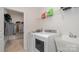 Practical laundry room with washer, dryer, utility sink, and shelving for storage solutions at 5043 Antebellum Dr, Iron Station, NC 28080