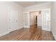 Spacious office featuring hardwood floors and a view into other rooms through glass panel french doors at 5043 Antebellum Dr, Iron Station, NC 28080